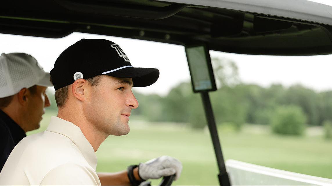 Two men in a golf cart on a golf course