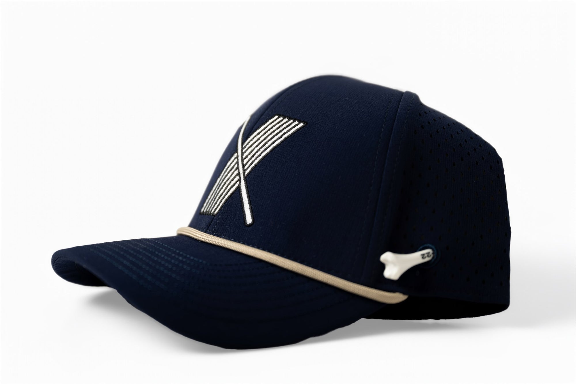 left side Navy blue golf hat with white embroidered X logo made of golf club and stripes, side view with contrast beige piping and perforated mesh back – The Quiet Lead Lid by 70x7 Golf Co.