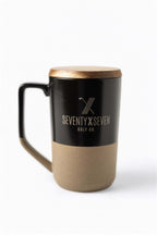 Dual-tone ceramic mug with black top, tan bottom, wooden lid, and SEVENTY X SEVEN Golf Co. logo on front – The Morning Round Mug by 70x7 Golf Co.